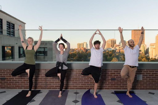 People doing yoga on a balcony