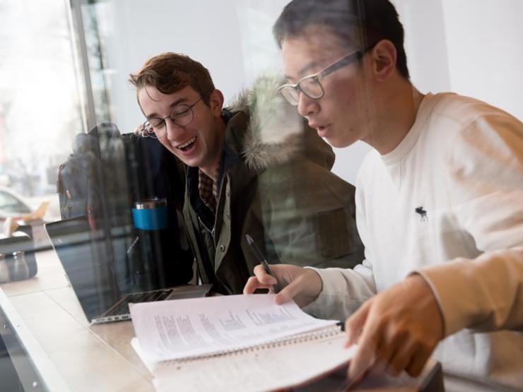 Two students sitting at table working together on school work