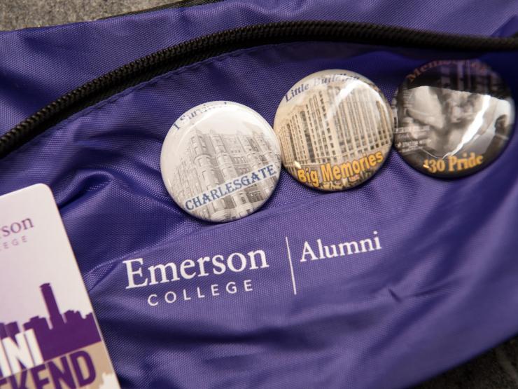 Zoomed-in shot of Emerson College Alumni bag with badges and tag placed on top