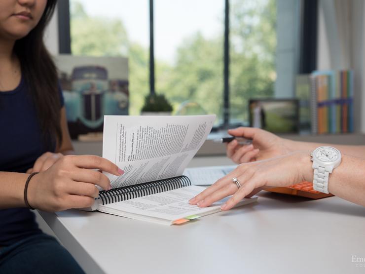 student reads a booklet with advisor