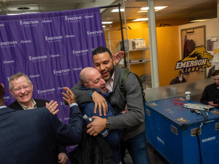 Alums hugging and greeting one another at an Emerson Lions alumni event