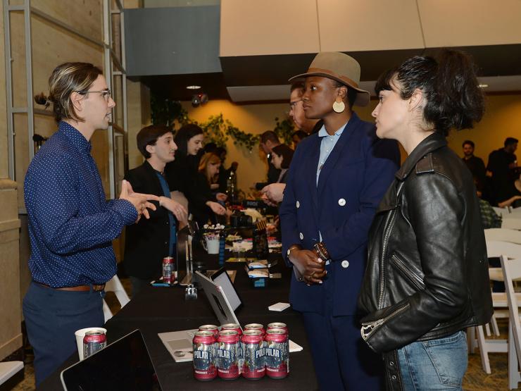 A student talks to two women at the 2019 E3 Expo.