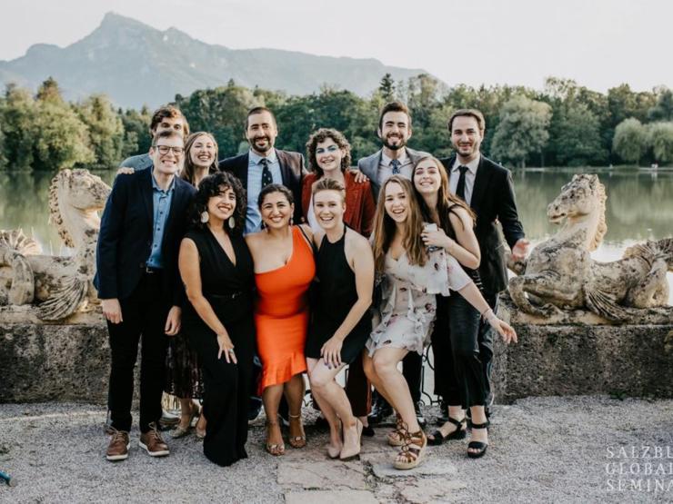 Students with professor smiling for a photo with the Alps in the background