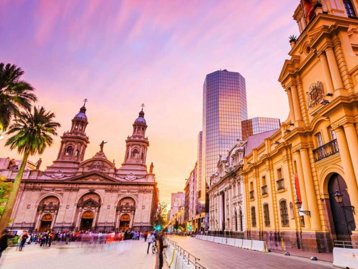 View of courtyard in Santiago in the evening with a church and people milling about