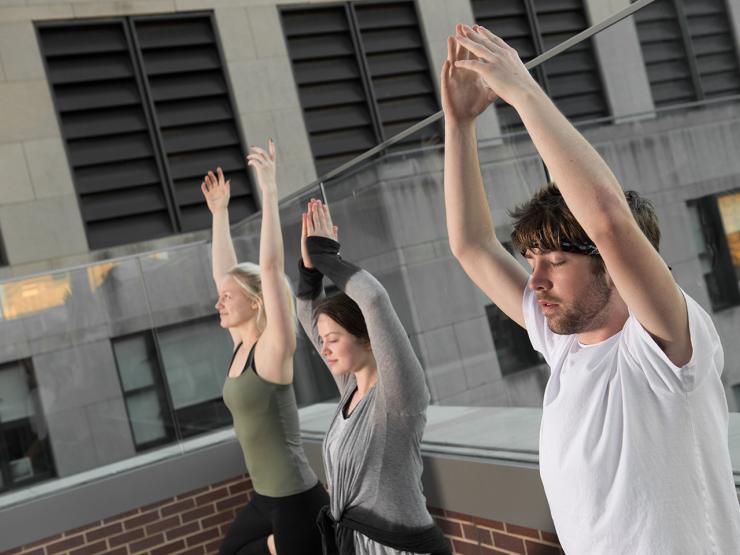 students doing yoga on the roof of a residence hall