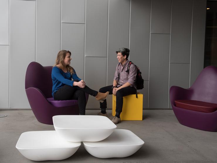 Two students facing each other and talking in common space at Emerson Los Angeles