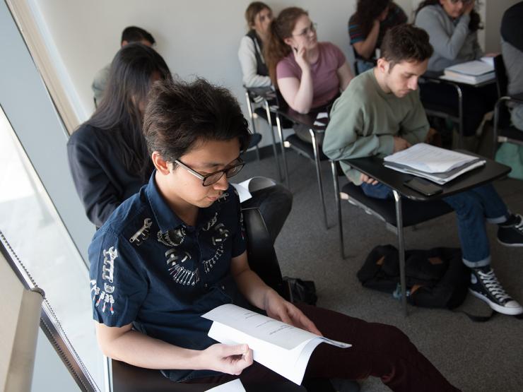 Students sitting in a classroom and looking at books at Emerson Los Angeles