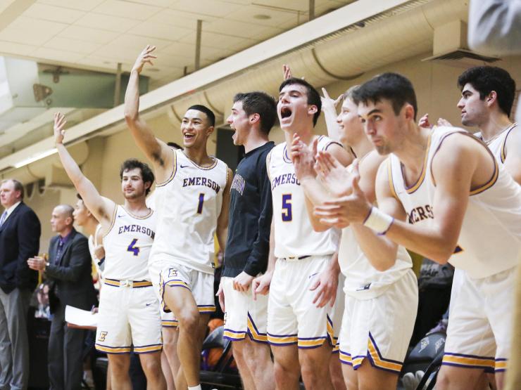 Men’s basketball players cheering on the bench.