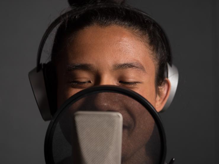 Portrait of student recording on microphone