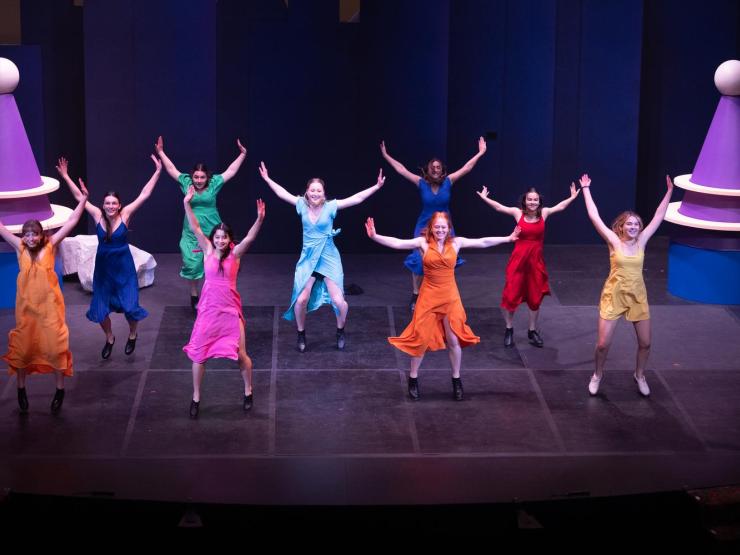 Students dancing in colorful dresses for orientation show