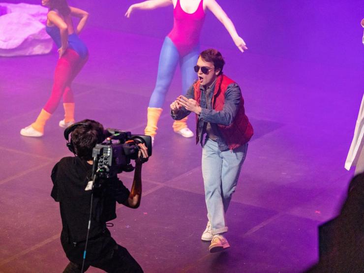 Students being filmed while performing on stage during Evvy ceremony