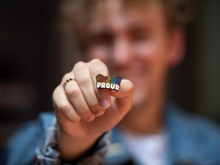 Student holding Pride pin