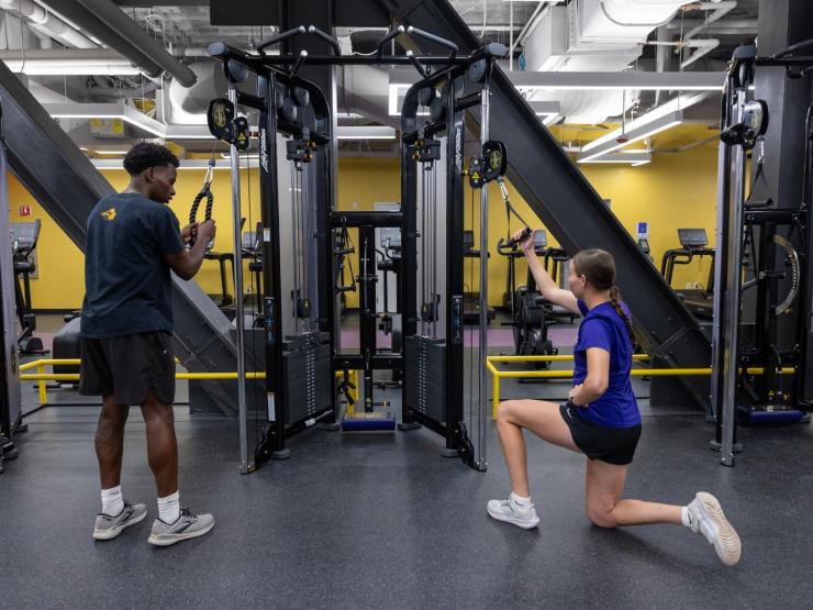 Students work out on a Life Fitness Bravo Dual Adjustable Pulley Station