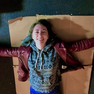 Student laying on a piece of cardboard