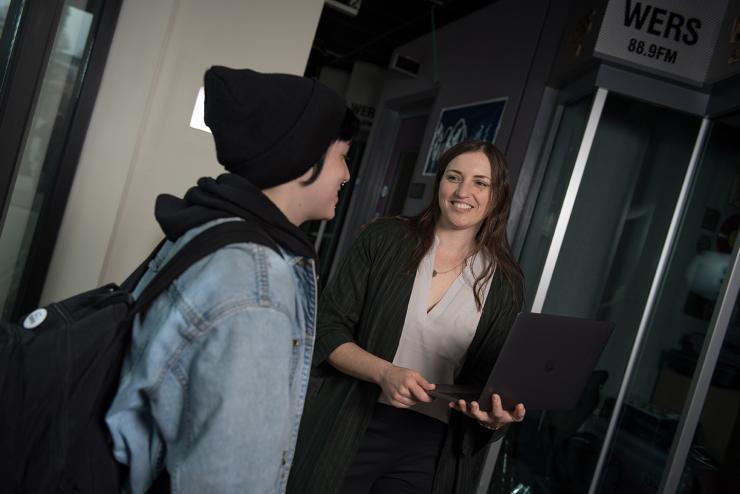 Two students talk outside of the WERS station