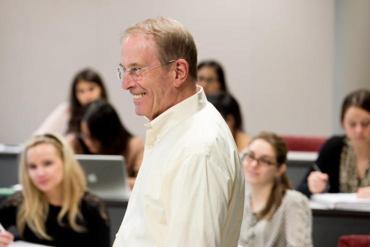 Faculty member smiling in a classroom of students