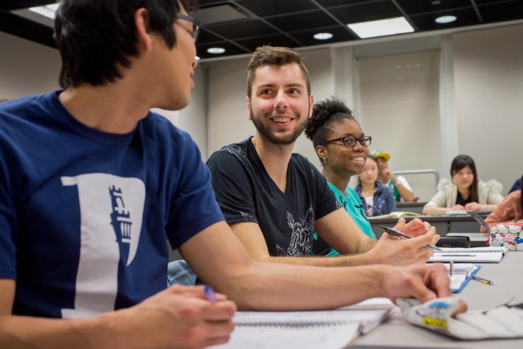 Students looking at each other while filling out paperwork