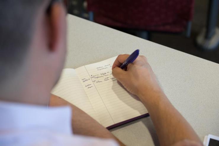 Over-the-shoulder of student taking notes