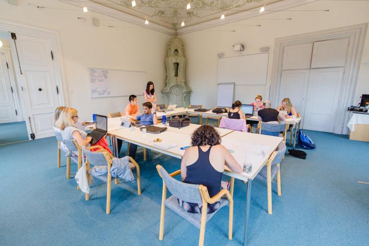 Students sitting at a table and working on laptops