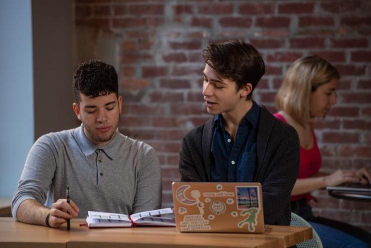 Students working at a table, with a laptop open