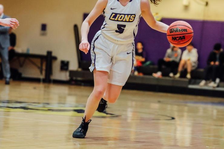 A student athlete running down a basketball court