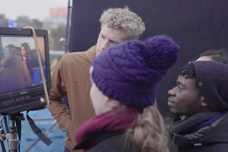 Crew huddled around the video monitor watching the actor perform