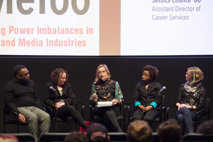 Panel of faculty and guest speakers on stage at event